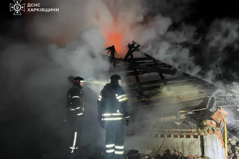 In this photo provided by the Ukrainian Emergency Service, emergency services personnel work to extinguish a fire at a private house following a Russian air attack in Bohodukhiv, Kharkiv