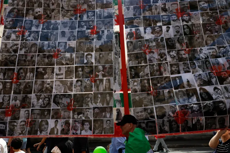 SYDNEY, AUSTRALIA - FEBRUARY 14: Members of the Iranian community hold placards as they march during a rally in the central business district (CBD) on February 14, 2026 in Sydney, Australia. Protestors called for a regime change and an end to recent violence and repression by the Islamic Republic regime in Iran. (Photo by Izhar Khan/Getty Images)
